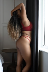 Curly haired curvy black girl striking a sexy pose
