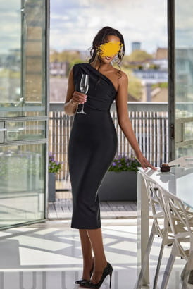 Fit elegant black woman in a long black dress holding a glass of champagne